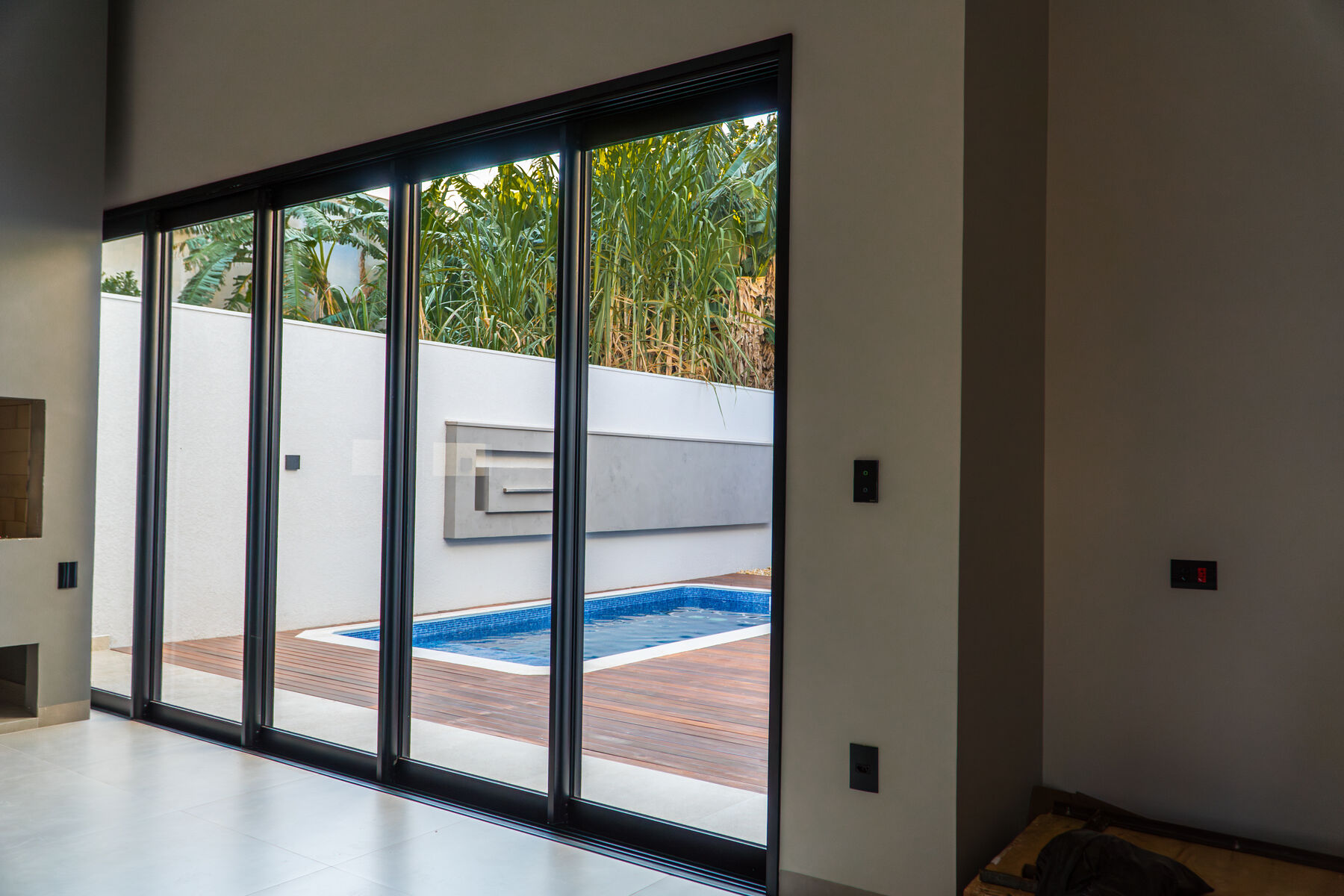 Porta de correr em alumínio preto com vista para a piscina