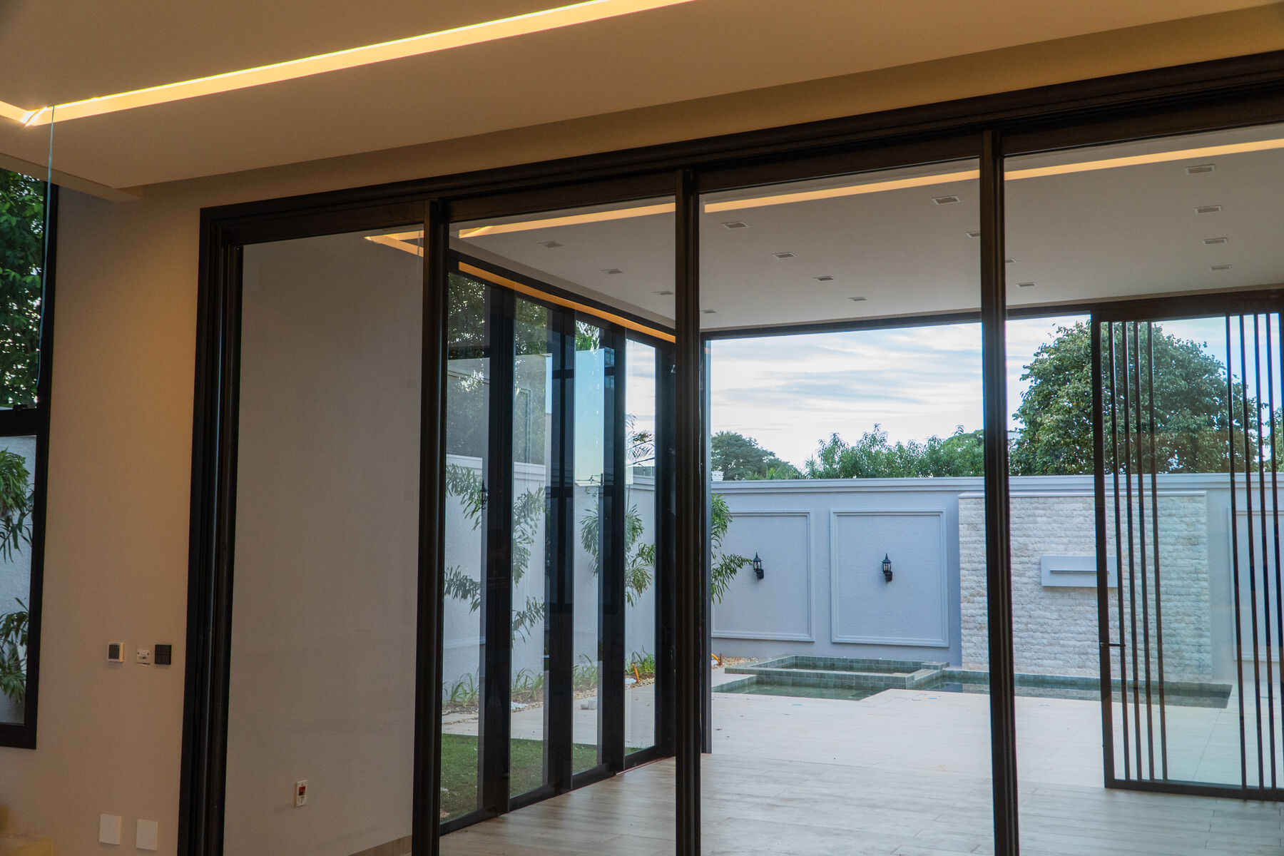Sala integrada com portas de alumínio abertas para o jardim